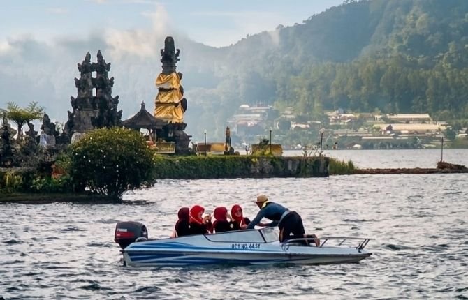 Boat ride on Lake Beratan with temple and misty mountains in the background
